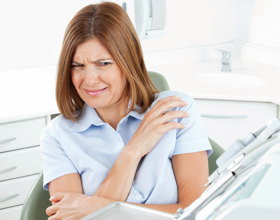 Angstpatientin sieht Zahninstumente angstvoll an