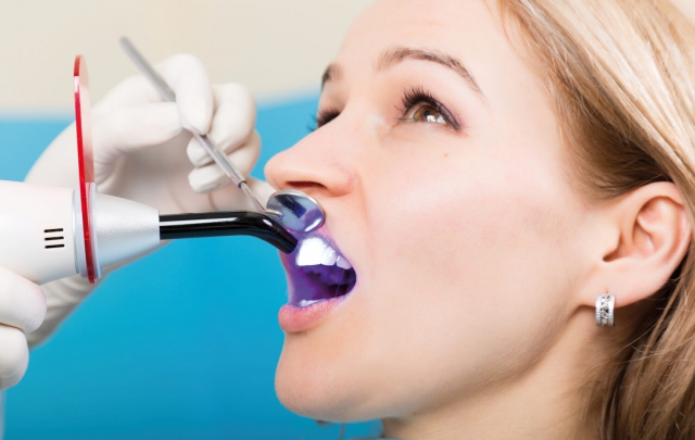 Patientin bekommt Zahnbleaching von Zahnarzt